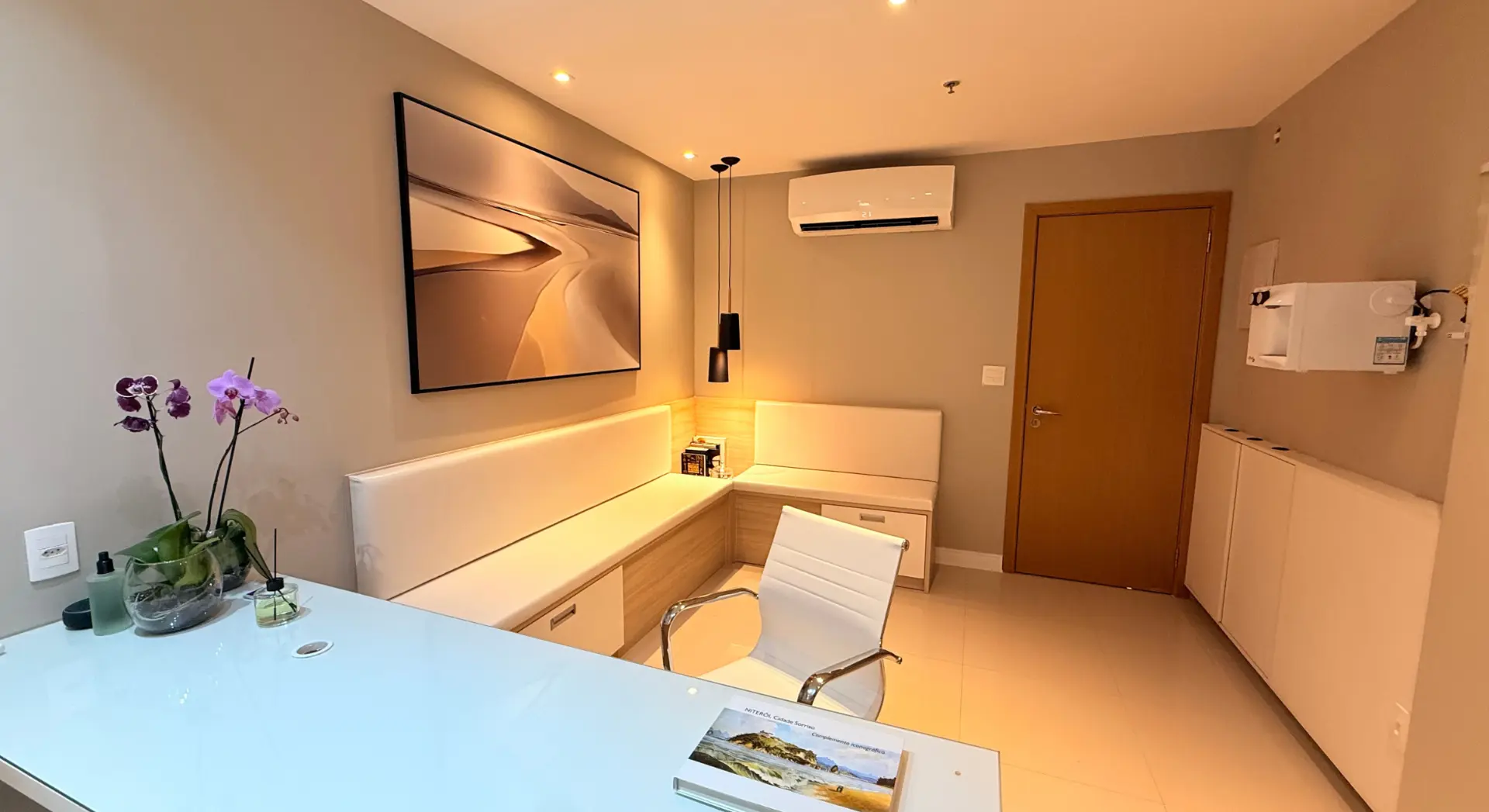 Recepção do consultório com poltronas e decoração clara